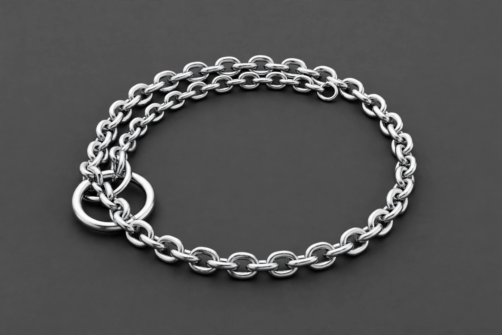 Coastal Pet Titan chrome chain training collar arranged in a loop, editorial product photo on gray background